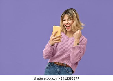 Excited crazy gen z blonde young woman winner with smartphone, happy shopper customer student girl screaming yes using mobile cell phone celebrating online prize win on purple background. - Powered by Shutterstock