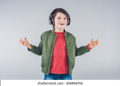 Excited Cute Boy With Headphones Gesturing Isolated On Gray