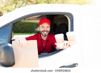 Excited Delivery Man Sitting Behind The Wheel And Delivering A Brown Bag With Takeout Food And Coffee To Go For Lunch. Courier Arriving To Make A Home Delivery