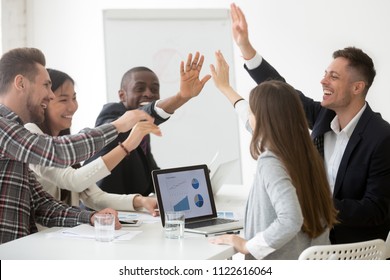 Excited Diverse Work Team Giving High Five At Board Meeting, Celebrating Shared Goal Achievement, Congratulating With Win Or Good Result, Showing Team Spirit, Unity. Concept Of Cooperation, Rewarding