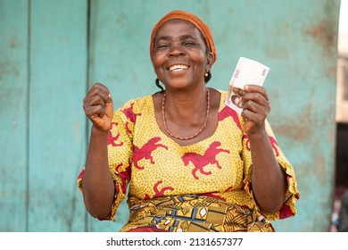 excited elderly african woman holding some money