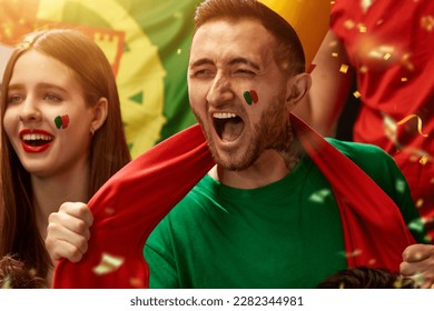 Excited and emotional people, portugal football fans emotionally cheering up favourite team during match at stadium. Concept of sport, competition, championship, emotions, hobby and entertainment - Powered by Shutterstock