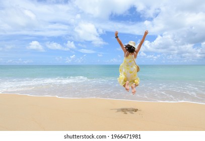 Excited energetic happy tourist girl is jumping at the beach on summer vacations, fun and freedom with new normal travel concepts