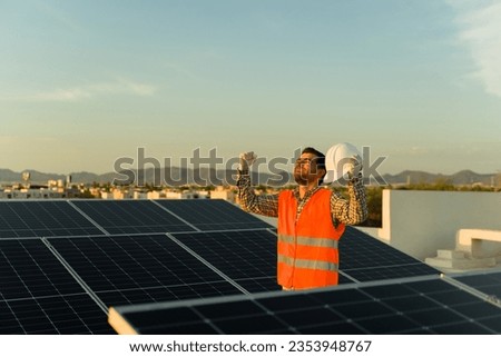 Excited engineer worker smiling and celebrating finishing a solar panel and photovoltaic cell installation at a residential home
