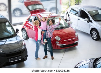 excited family buying a new car in the car dealership  saloon
