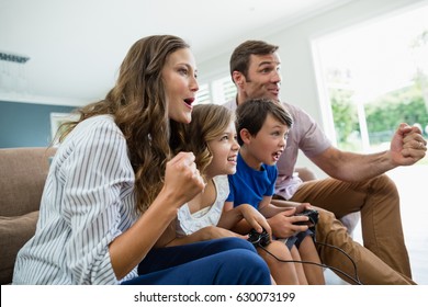Aufgeregt spielende Familie im Wohnzimmer zu Hause