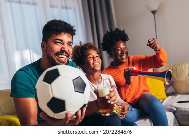 Excited Family Watching Football Match At Home