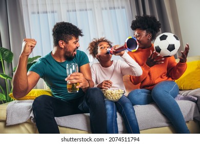 Excited Family Watching Football Match At Home