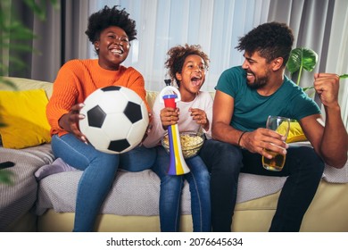 Excited Family Watching Football Match At Home