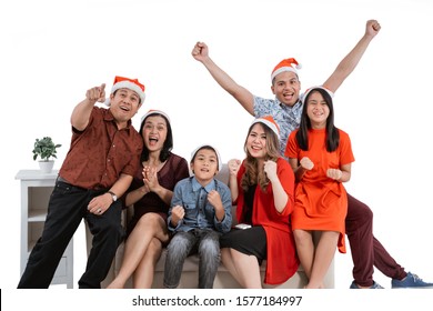 Excited Family Watching Tv Together Wearing Christmas Head