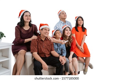 Excited Family Watching Tv Together Wearing Christmas Head