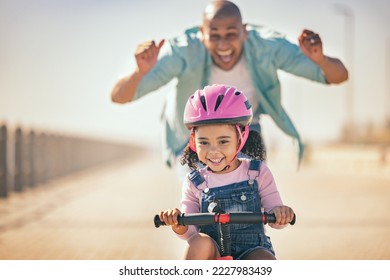 Excited father teaching girl to ride a bike in sunshine, summer fun and beach promenade outdoors. Happy kid, learning and riding bicycle with help from dad, parent and safety for healthy development - Powered by Shutterstock