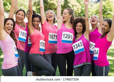 Excited female breast cancer marathon runners cheering in park