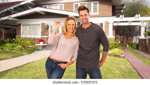 Excited First Time Homebuyers Standing In Front Of Their New Home