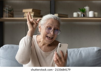 Excited Freaky Grandma Talking On Video Call To Grandchildren, Making Devils Horn Rocker Finger Gesture, Laughing, Smiling At Smartphone Screen, Having Fun, Enjoying Distant Communication With Family