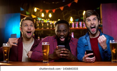Excited friends rejoicing watching horse race   making bets online  income