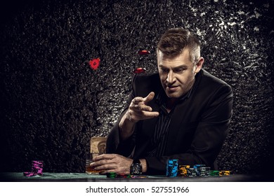 Ein aufgeregter Glücksspieler, der Chips auf einen Spieltisch in einem Casino wirft. Glücksspiel, Spielkarten und Roulette.