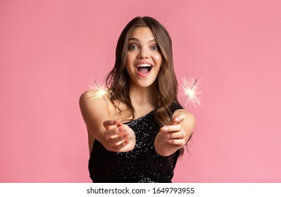 Excited Girl Holding Sparklers, Enjoying Party, Celebrating Anniversary Or New Year, Posing Over Pink Background With Free Space