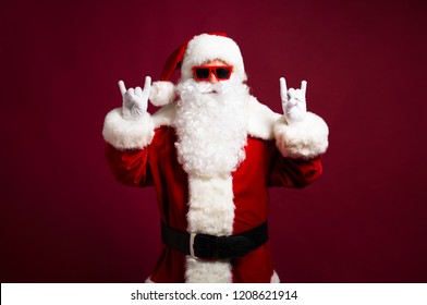Excited grandfather Santa Claus is dancing and have a fun in sunglasses. Happy New Year, Merry Christmas, Celebration concept, travel, trips, party time, isolated on red background