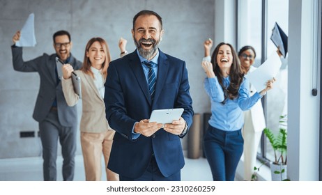 Excited group of coworkes embracing and jumping during a celebration. Business people smile and raise hands up, feeling happy, complete finish job, teamwork successfulachievement working in office - Powered by Shutterstock