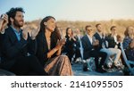 Excited Guests Sitting in an Outdoors Venue and Clapping Hands. Multiethnic Beautiful Diverse Crowd Celebrating an Event, Wedding or Concert. Inspiring Day with Beautiful Warm Weather.