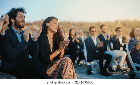 Excited Guests Sitting In An Outdoors Venue And Clapping Hands. Multiethnic Beautiful Diverse Crowd Celebrating An Event, Wedding Or Concert. Inspiring Day With Beautiful Warm Weather.