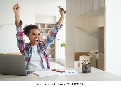 Excited happy african american girl student got good exam test scores on laptop. Overjoyed teenage schoolgirl raising hands screaming celebrates personal achievement or finishing homework. - Powered by Shutterstock