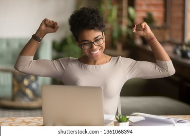 Excited happy african american woman feeling winner rejoicing online win got new job opportunity, overjoyed motivated mixed race girl student receive good test results on laptop celebrating admission - Shutterstock ID 1361068394