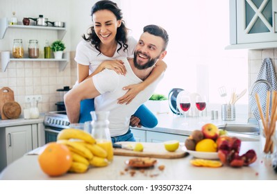 Excited happy beautiful young couple in love cooking in the kitchen and having fun together while making fresh healthy fruits salad - Powered by Shutterstock