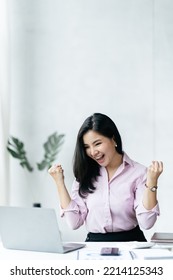 Excited Happy Business Woman Looking At Computer Laptop Screen, Cheerful Young Asian Woman Using Computer Laptop And Receiving Good News From The Message On Laptop Chat Application.