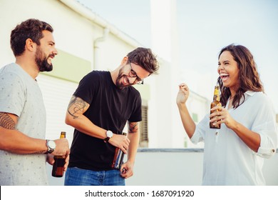 Excited Happy Friends Drinking Beer, Chatting And Laughing On Outdoor Terrace. Young Men And Woman In Casual Meeting Outside. Old Friends Meeting Or Fun Concept