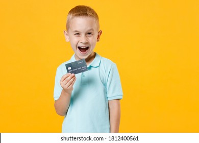 Excited Happy Little Fun Male Kid Boy 5-6 Years Old Wearing Stylish Blue Turquoise T-shirt Polo Hold In Hand Mockups Of Credit Bank Card Isolated On Yellow Color Wall Background Child Studio Portrait