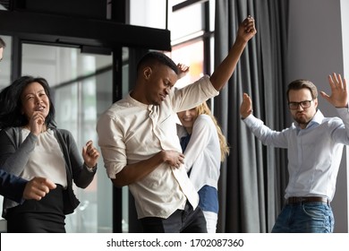 Excited Happy Multiracial Businesspeople Have Fun Engaged In Activity In Office Together, Overjoyed Diverse Colleagues Dance Celebrate Successful Business Project, Friday Celebration Concept