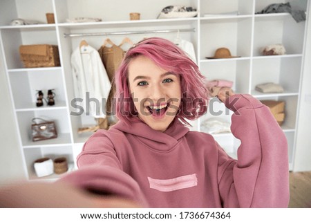 Excited hipster gen z teen girl fashion social media channel blogger stylist with pink hair piercing wear hoodie look at camera record vlog video tutorial in front of clothes wardrobe, face headshot.