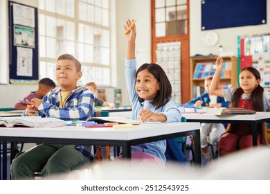 Excited hispanic little girl raising hand in elementary classroom. School children during the lesson trying to answer question in primary school. Cute little latin girl raising hand at school. - Powered by Shutterstock