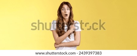 Excited impresseed speechleess shocked girl loose speech drop jaw gasping astonished asking friend advice how react stare camera opened mouth pointing left stand yellow background ambushed. Lifestyle. Stock foto © 