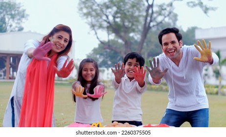 An excited Indian family showing their colorful hands together on the Holi festival - togetherness and bonding, an urban family. Cheerful siblings posing together for the camera with their parents ... - Powered by Shutterstock