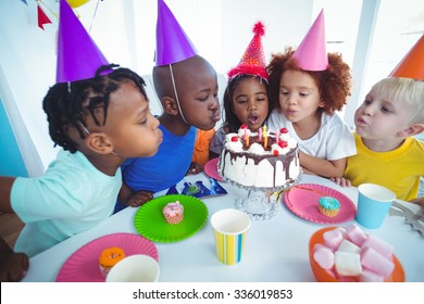 Excited kid enjoying a birthday party blowing out the candles