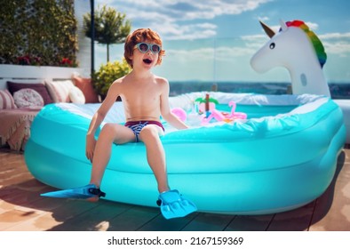 Excited Kid Having Fun Sitting On Inflatable Pool On Summer Patio