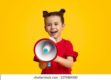 Excited Kid Leader Speaking In Megaphone And Smiling While Standing Against Yellow Background. Young Leader Concept