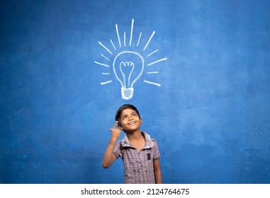 excited Kid with suddenly got or pop up idea expression under light doodle on blue background - concept of child found solution, creativity and brainstorm.