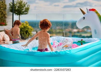 excited kids having fun in inflatable pool on summer patio. jumping and splashing around - Shutterstock ID 2283107283