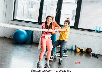 Excited Kids Playing Tug Of War In Gym