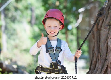 Excited Little Boy Enjoying Climbing At Adventure Park