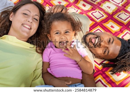 Similar – Image, Stock Photo Child laughing joyfully while making a snow angel, dressed in a vibrant winter coat and hat