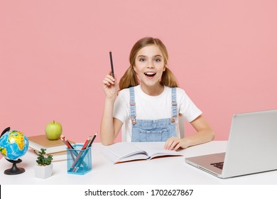 Excited Little Kid Schoolgirl 12-13 Years Old Study At Desk With Pc Laptop Isolated On Pink Background. School Distance Education At Home During Quarantine Concept. Point Pen Up With Great New Idea