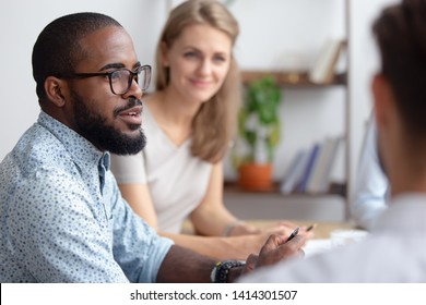 Excited male african-american talking to coworkers timeout in office informal partners conversation. Black manager telling interesting story, sharing news, business strategy. Blur background