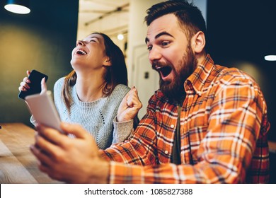 Excited male and female hipsters rejoice in winning an internet lottery made bets on website on modern smartphone.Happy couple in love celebrating victory in online competitions enjoying success - Shutterstock ID 1085827388