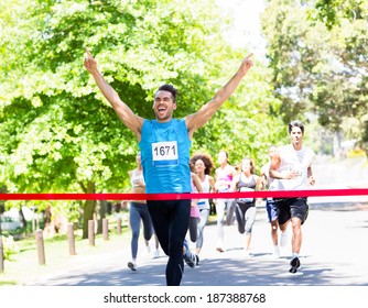 Excited male runner crossing the finshline of a marathon