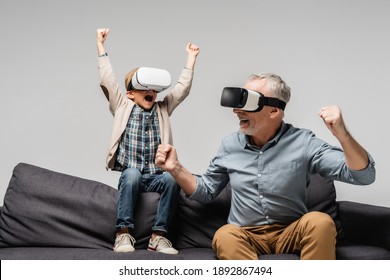 excited man and boy in vr headsets showing win gesture isolated on grey - Powered by Shutterstock